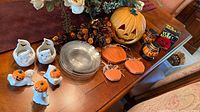 Full lot on dining table – figurines, plates, pumpkin ornaments, lanterns, garland, plastic pumpkin, napkins