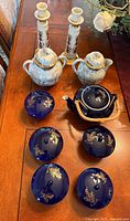Lot overview showing Lenox candlesticks, two pale blue lidded pots, cobalt teapot, and four lidded bowls