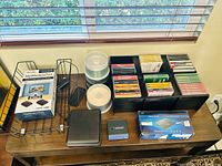 Overall lot on tabletop showing discs in holders, two boxed kits, peripherals