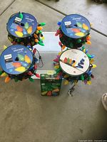 Four storage spools with multicolor C9 LED bulbs, boxed string light in front