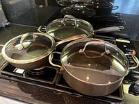 All three OXO nonstick pots/pans with lids on stovetop