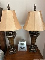 Front view of both bronze urn lamps with shades and Timex clock radio
