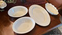 Two oval bowls, oval platter, scalloped bowl on table