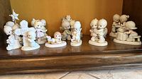 Front view of all 10 Precious Moments figurines grouped on shelf