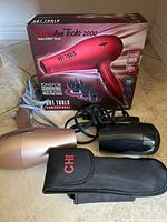 Boxed Hot Tools hair dryer, two loose dryers, CHI case visible