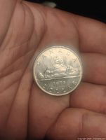 Reverse of 1975 Canadian dollar showing CANADA, canoe scene, year and denomination