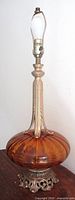 Full view of brass and amber glass table lamp