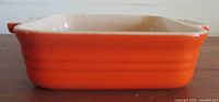 Side view of square burnt orange baking dish showing exterior color and height
