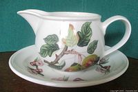 Pitcher on underplate showing fruit and blossom motifs