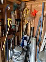 Overall view of shed wall showing sandblast kit, long-handled tools, poles and tubes