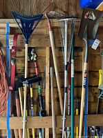 Group of long-handled tools hanging on wall
