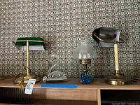 Group shot showing both banker lamps, swan vase and oil lamp with blue bird base