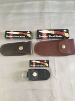 Three boxed knives with corresponding leather sheaths