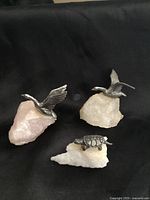 Three pewter animal figurines on quartz bases: two birds, one turtle