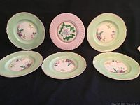 Front view showing all six plates: five mint green Royal Winton, one pink Burgess & Leigh
