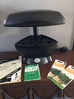 Front view of AeroGarden unit with manuals and power cord