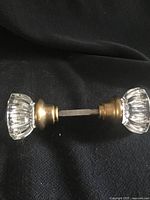 Side view of complete glass door knob set showing both knobs and brass hardware