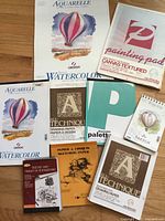 All nine artist pads laid out to show variety of covers and sizes