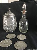 Overall lot view showing jar, decanter, four coasters