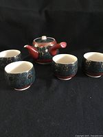 Teapot with four cups front view