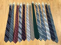 All 13 wool neckties laid flat showing colours and patterns.