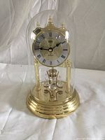 Front view of anniversary clock under glass dome