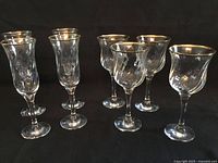 All eight gold-rimmed stemware pieces grouped together