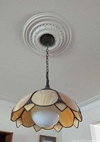 Fixture hanging from ceiling showing full shade design and chain