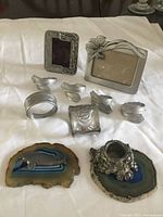 all items laid out: two frames, six napkin rings, whale on agate, candleholder on agate