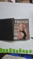 Binder opened showing International Tattoo magazine cover