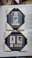 Two framed hockey card displays in protective corner sleeves on table