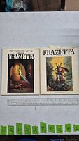 Front covers of both Frank Frazetta art books with ruler for scale