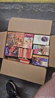 Open cardboard box filled with romance paperback novels