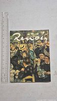 Front cover of Renoir art book beside ruler for scale