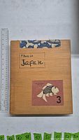 Front of wooden slipcase showing title label and koi illustration