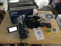 Full lot overview showing camcorder, box, batteries, discs, strap and accessories