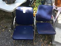 Two blue folding theatre chairs side by side