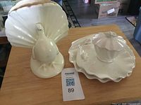 Peacock figurine and shell dish set on table