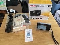 Camera, accessories and box laid out on table with lot card