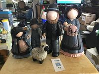 Group view of four Amish figurines and sheep on table