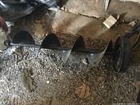 Full view of steel spiral auger bit on ground