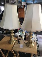 Both brass table lamps with shades on small tables