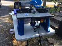 Front view of Mastercraft router table showing base, tabletop, fence, guard, and mounted router
