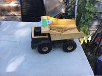 Left side view of yellow and black Tonka dump truck on table