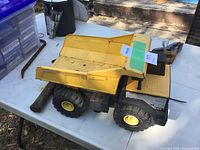 Left side view of Tonka dump truck showing metal bed and wheels