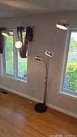 Full view of 5-arm arc floor lamp next to windows