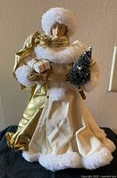 Front view of ivory and gold standing angel holding present and tree