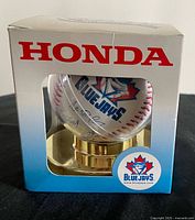 Front view of sealed Blue Jays baseball in Honda-branded sleeve