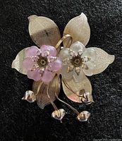 Front view showing gold-tone leaves, pink and white flowers, dangling buds