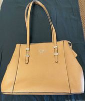 Front view of tan Guess tote handbag with logo and dual straps